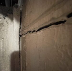 Basement wall has a deep crack and is beginning to bow inward.