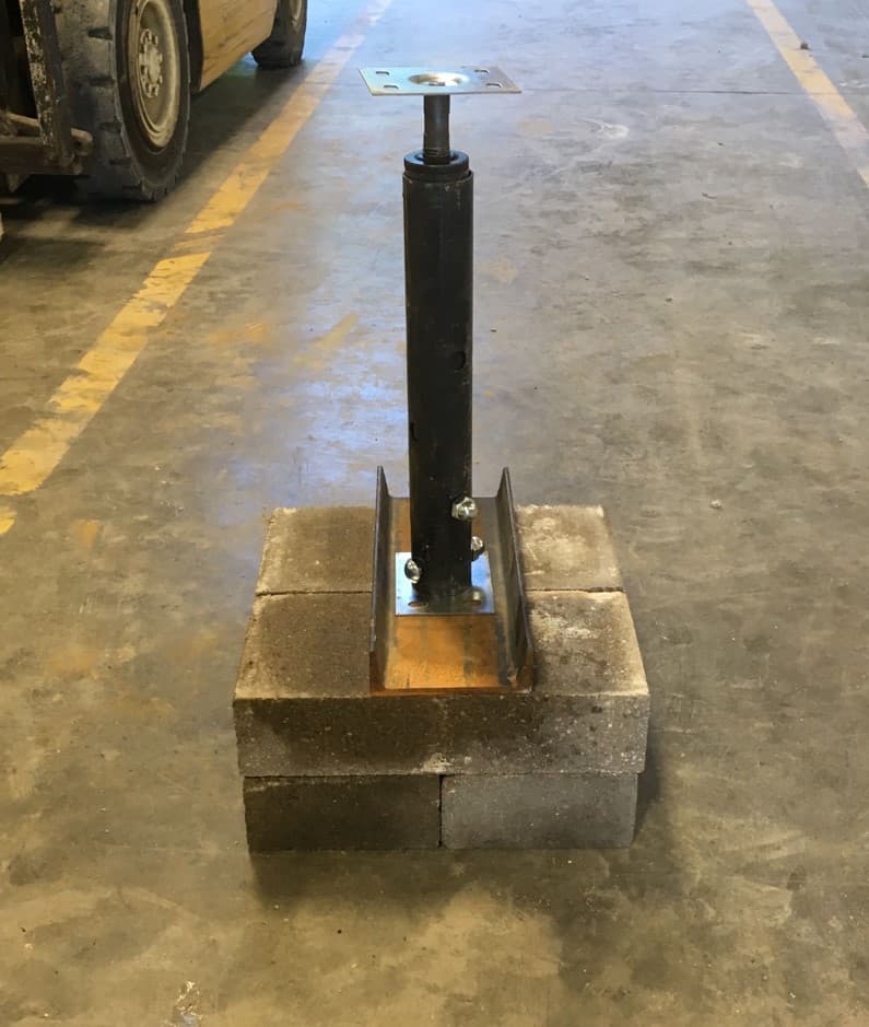 steel jack resting on a concrete block base
