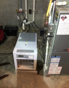 Dehumidifier installed next to sump pump pit